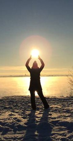 Ihminen rannalla, aurinko paistaa tämän pään päältä